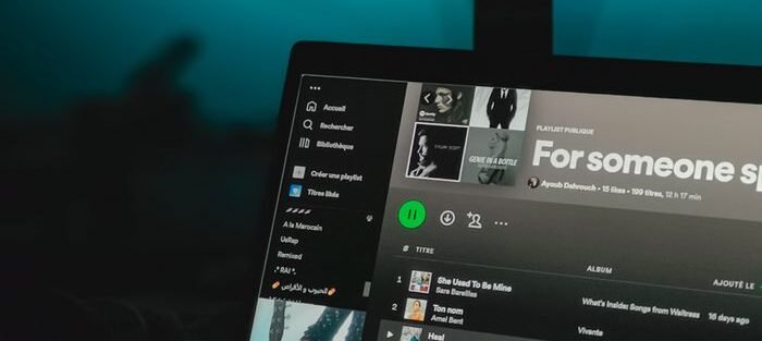 Laptop displaying a music playlist on a streaming service screen.