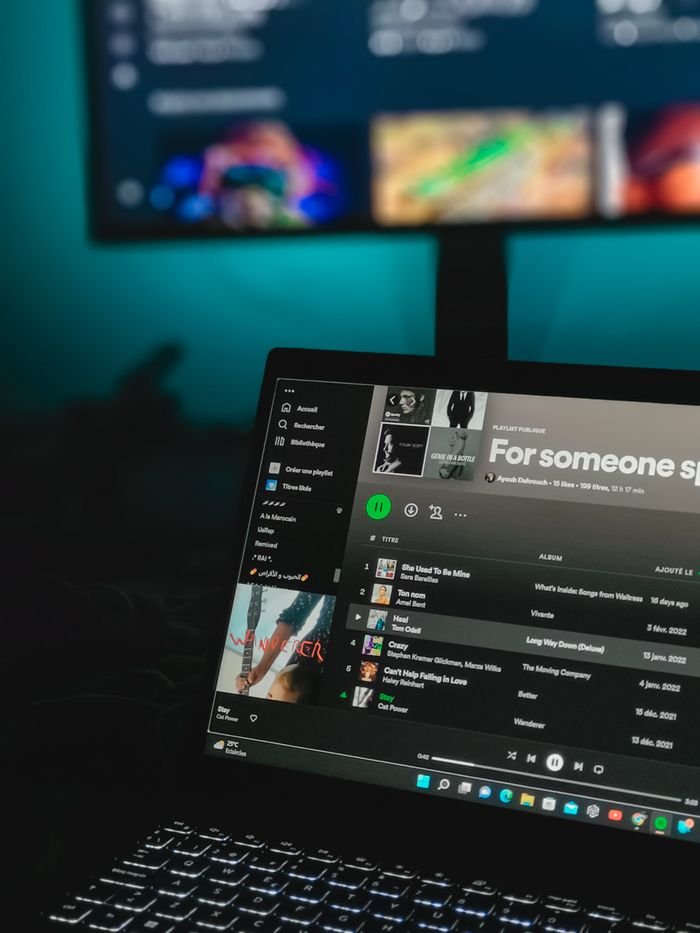 Laptop displaying a music playlist on a streaming service screen.